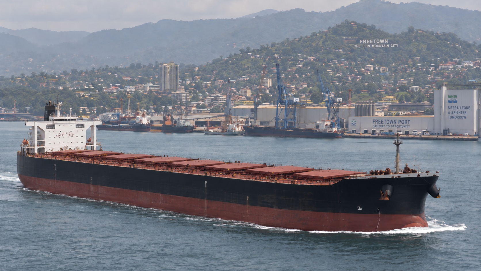 Bulk carrier in front of Freetown port and the city hillside